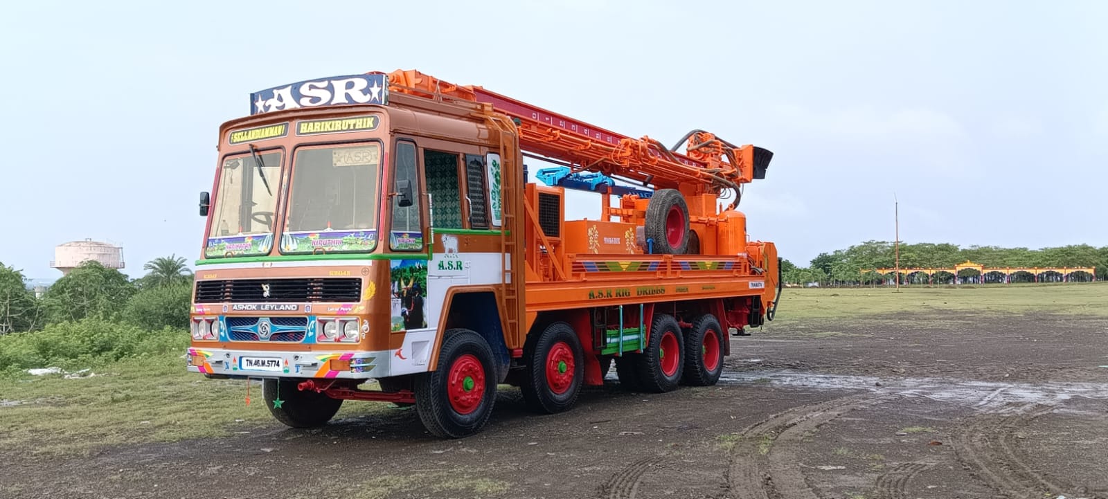 Orange borewell rig truck parked on an open site